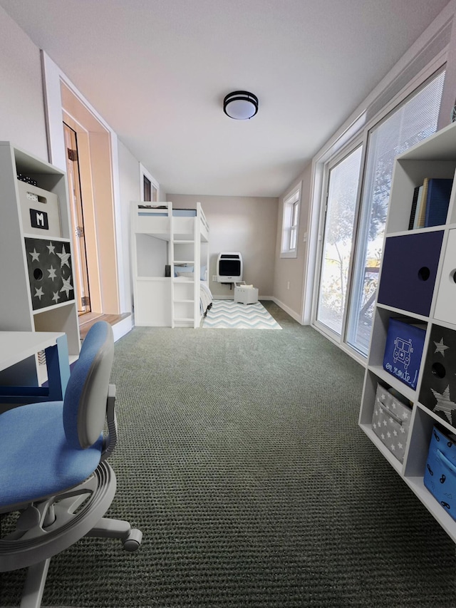 carpeted office with heating unit and baseboards