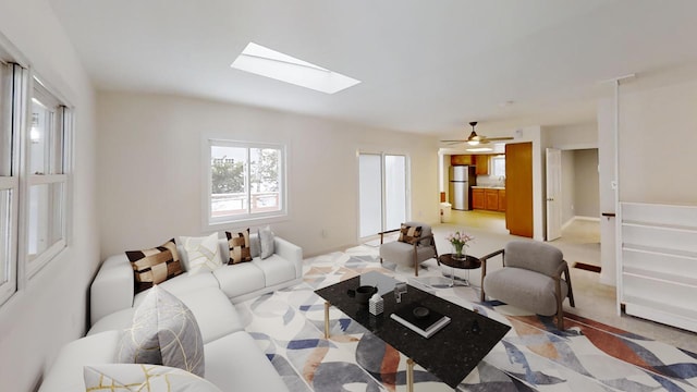 living area featuring a skylight and baseboards