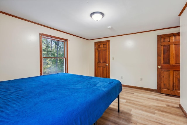 bedroom featuring ornamental molding and light hardwood / wood-style floors