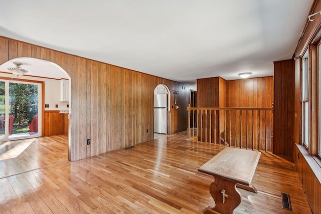 interior space with wooden walls and light wood-type flooring