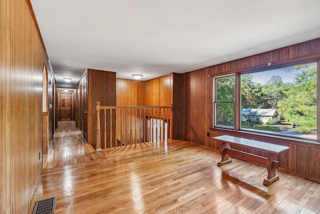 misc room with wood walls and light hardwood / wood-style floors