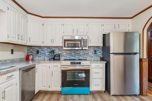 kitchen featuring stainless steel appliances, light stone countertops, light wood-type flooring, and white cabinetry