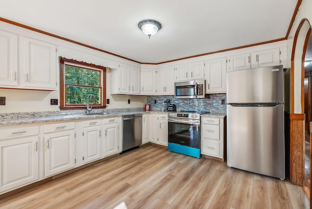 kitchen featuring stainless steel appliances, light hardwood / wood-style flooring, sink, and white cabinetry