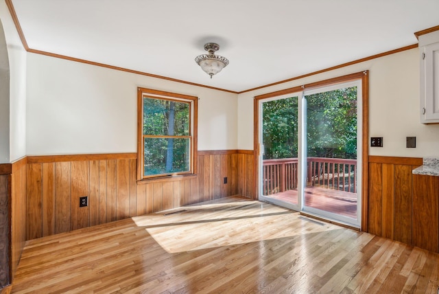 unfurnished room featuring crown molding and light hardwood / wood-style floors