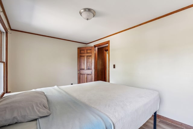 bedroom with light hardwood / wood-style flooring and ornamental molding