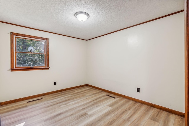 unfurnished room with crown molding, light wood-type flooring, and a textured ceiling