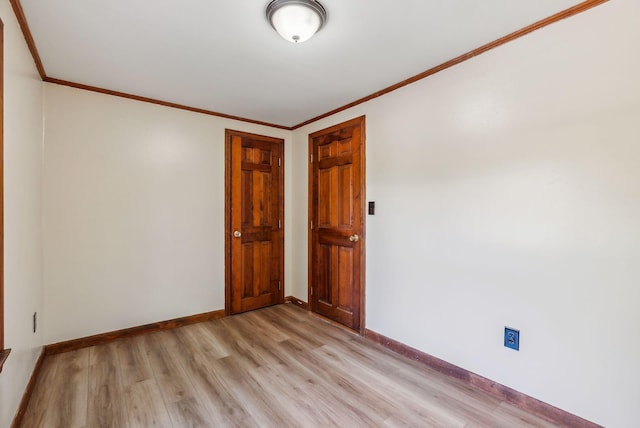 unfurnished room with crown molding and light hardwood / wood-style floors