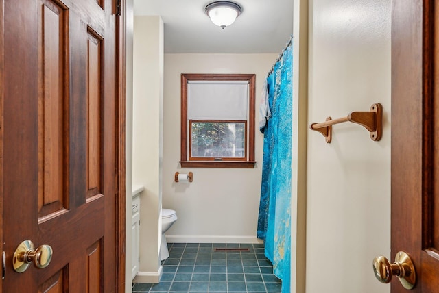 bathroom with a shower with curtain, vanity, tile patterned flooring, and toilet