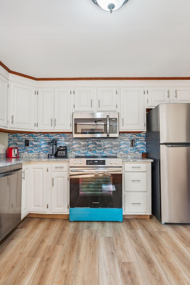 kitchen featuring appliances with stainless steel finishes, light wood-type flooring, and white cabinets