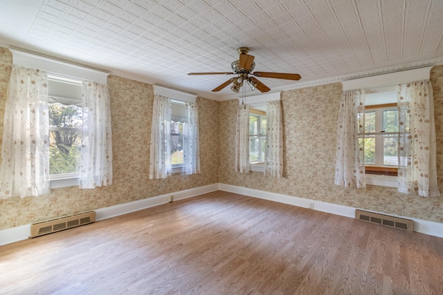 unfurnished room with ceiling fan, hardwood / wood-style flooring, and plenty of natural light