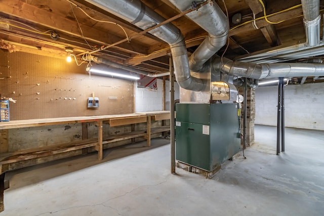 basement featuring a workshop area and heating unit