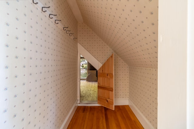 additional living space featuring hardwood / wood-style flooring and vaulted ceiling