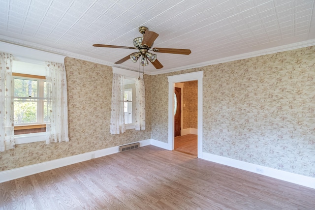 empty room featuring ceiling fan, hardwood / wood-style flooring, and ornamental molding