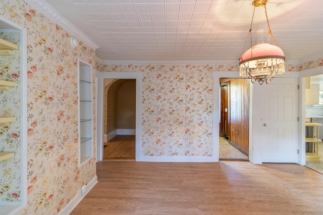 spare room with a notable chandelier and hardwood / wood-style floors