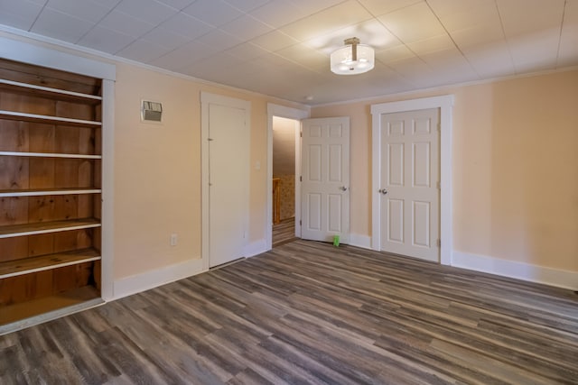 unfurnished bedroom featuring dark wood-type flooring and crown molding