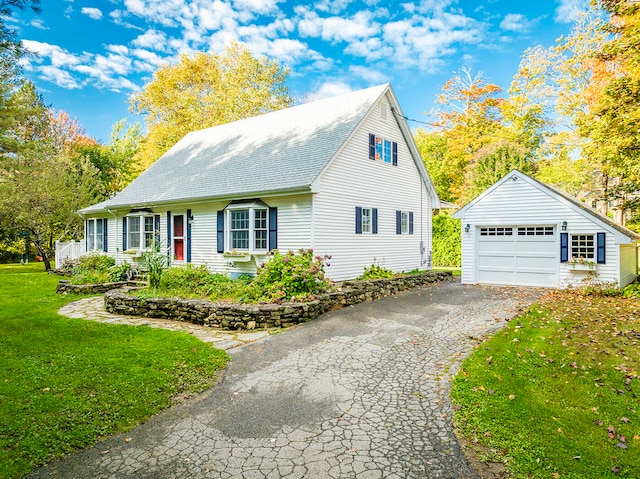 view of front of home with a garage, an outbuilding, and a front lawn