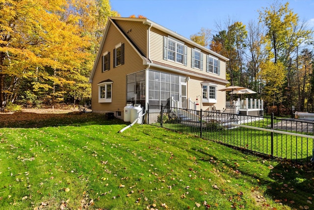 back of house featuring a yard and a sunroom