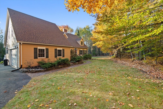 view of side of home featuring a yard and a garage