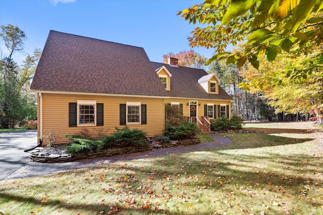 cape cod-style house with a front lawn