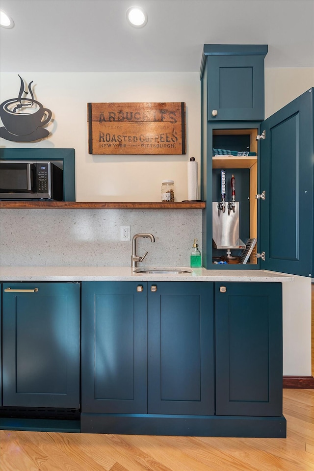 kitchen featuring blue cabinetry, sink, and light hardwood / wood-style floors