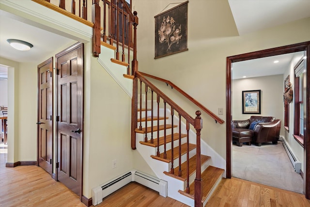 staircase with a baseboard radiator and wood-type flooring