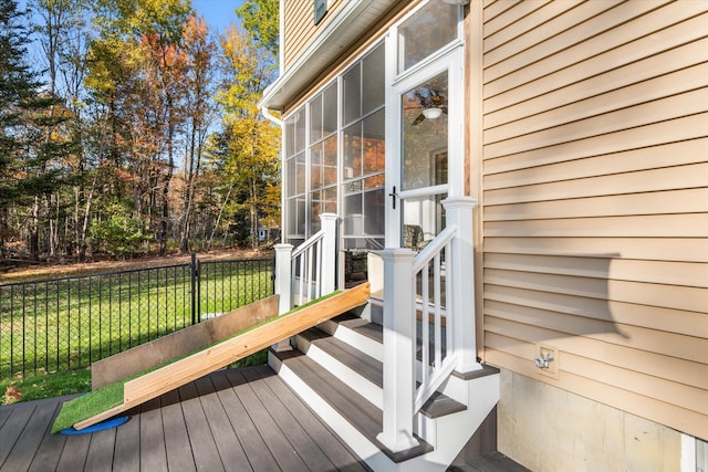 wooden deck featuring a yard and a sunroom