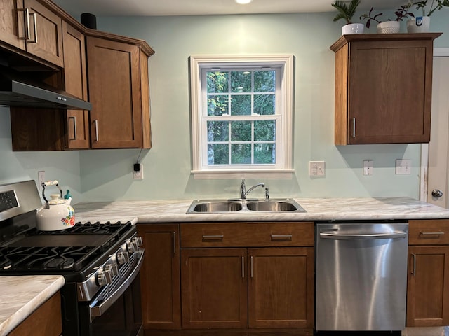 kitchen with appliances with stainless steel finishes, sink, and extractor fan