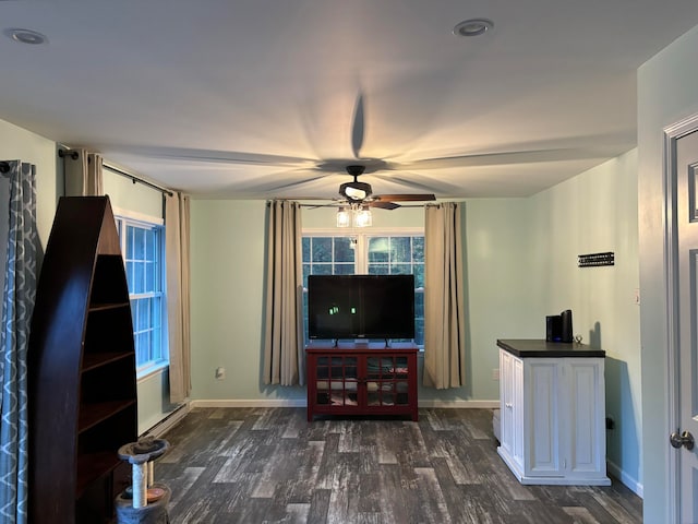 unfurnished living room featuring ceiling fan and dark wood-type flooring