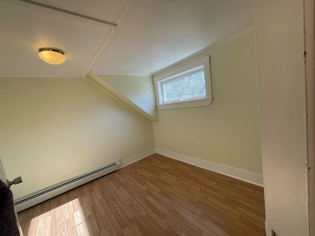 additional living space with lofted ceiling, hardwood / wood-style floors, and a baseboard heating unit