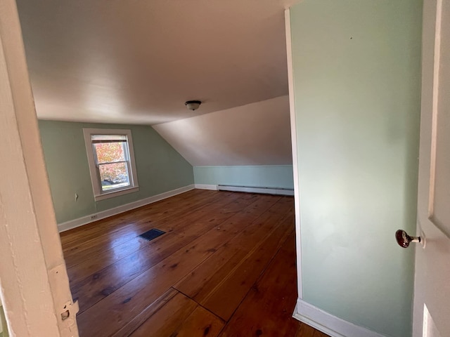 additional living space featuring a baseboard radiator, vaulted ceiling, and dark hardwood / wood-style flooring