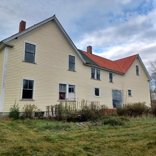 rear view of property with a lawn