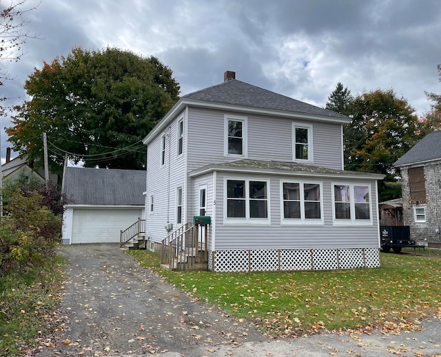 view of front of property with an outbuilding, a front lawn, and a garage