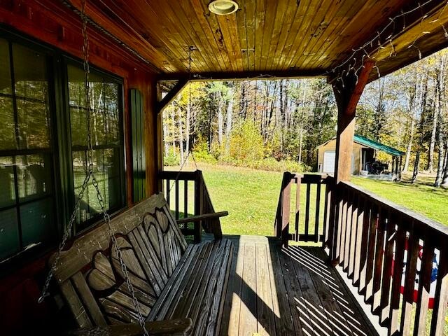 wooden terrace with a yard and an outdoor structure