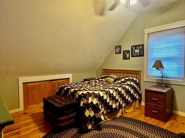 bedroom with vaulted ceiling, light hardwood / wood-style flooring, and ceiling fan