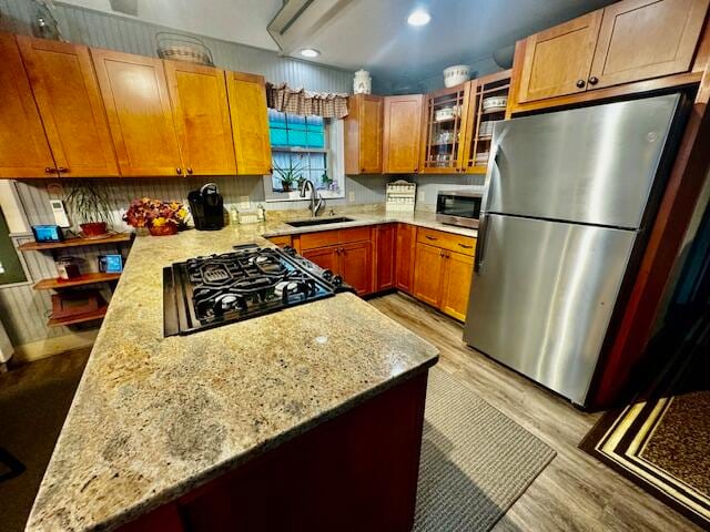 kitchen with light stone countertops, sink, and appliances with stainless steel finishes