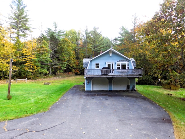 468 Curtis Rd, Swanville, ME 04915 - view of front of house with a front yard, a gambrel roof, an attached garage, and a deck