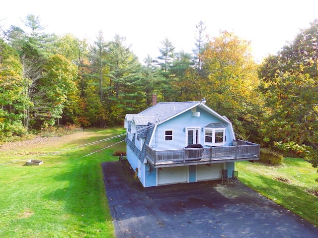 view of front of property with a front lawn, a wooden deck, and a garage