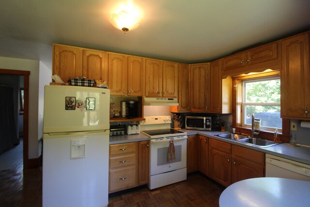 kitchen with sink, dark parquet flooring, and white appliances