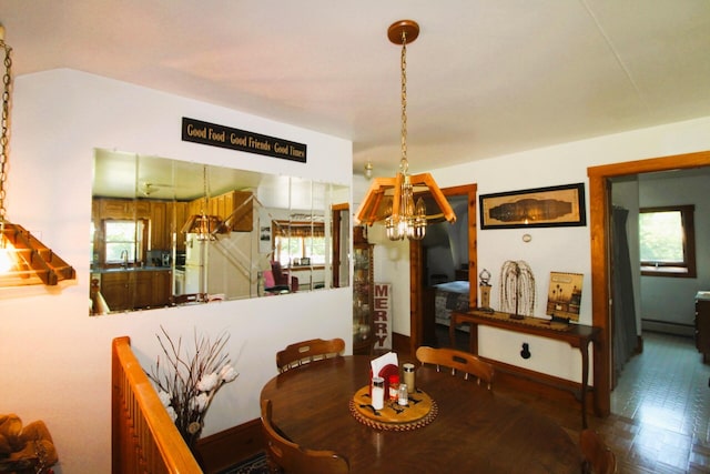 dining space featuring sink, parquet flooring, a chandelier, and plenty of natural light