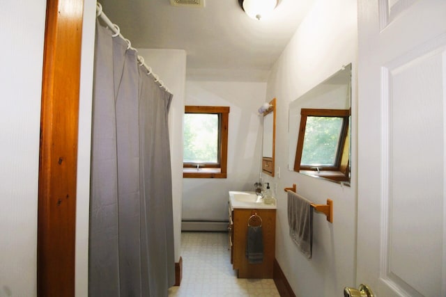 bathroom with vanity, a skylight, a shower with shower curtain, and a baseboard radiator