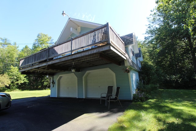 view of home's exterior with a wooden deck, a lawn, and a garage