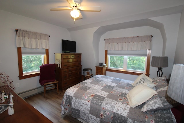 bedroom featuring baseboard heating, hardwood / wood-style floors, and ceiling fan