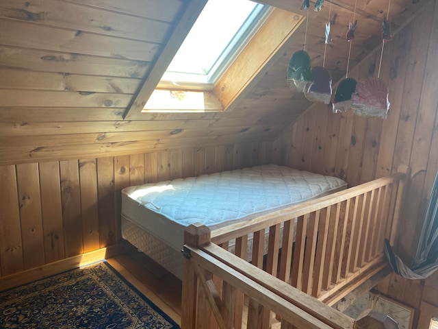 bonus room with lofted ceiling with skylight and wooden walls