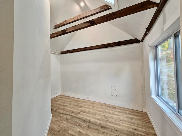 unfurnished room featuring light hardwood / wood-style floors, high vaulted ceiling, and beam ceiling