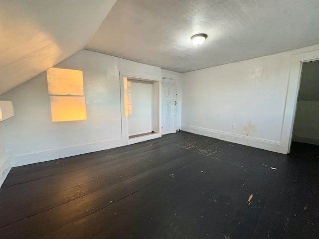 interior space featuring baseboards and vaulted ceiling