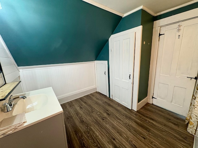 bathroom featuring hardwood / wood-style floors, vanity, crown molding, and vaulted ceiling