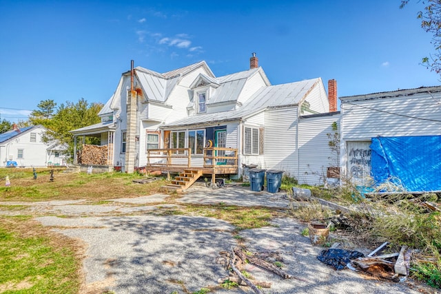 rear view of house with a sunroom and a wooden deck