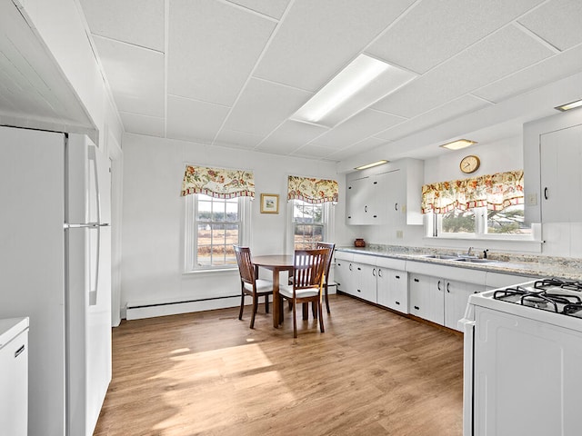 kitchen featuring white appliances, white cabinetry, light hardwood / wood-style flooring, and a baseboard radiator