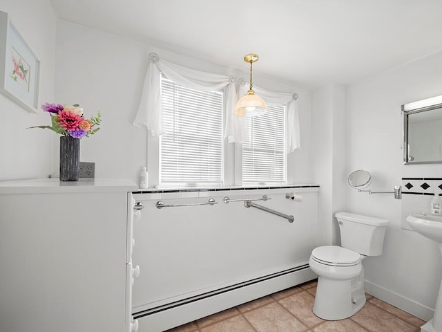 bathroom featuring tile patterned flooring, toilet, and a baseboard heating unit