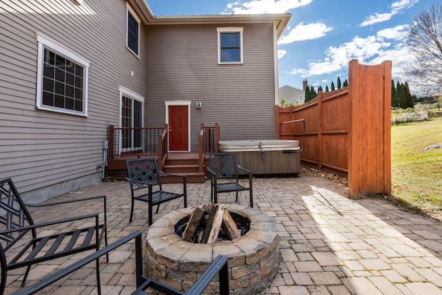 view of patio / terrace with a hot tub and a fire pit